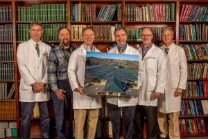 Doctors posing with photo of solar panels